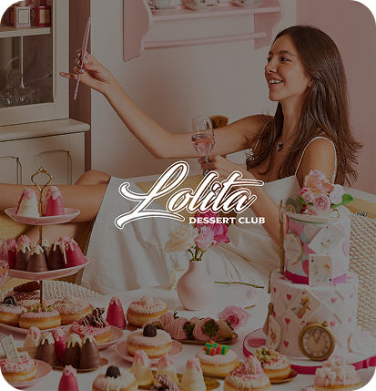 Woman with a white dress posing with a glass of water and variety of sweets in fron of her